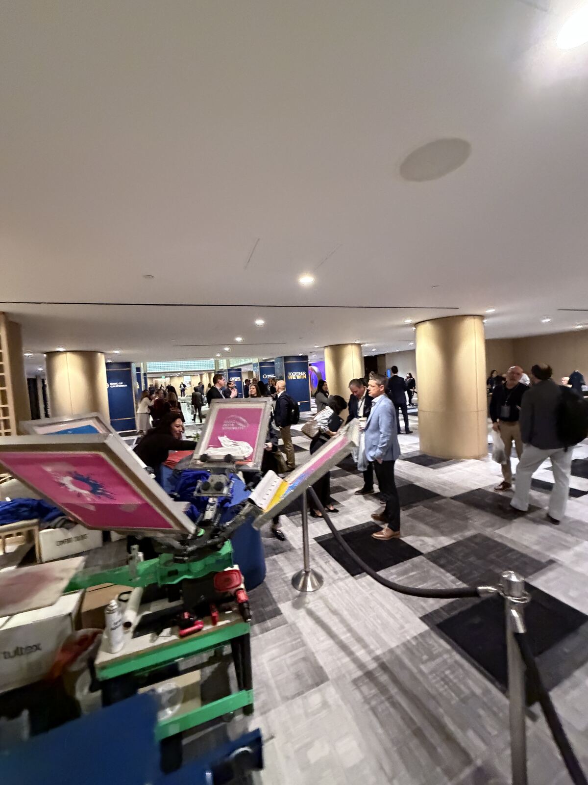 Indoor event booth with multiple visitors and merchandise displayed on shelving